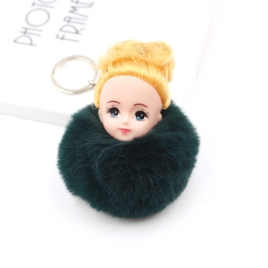 Détail d'un porte-clés poupée avec pompon en fausse fourrure vert foncé et cheveux dorés