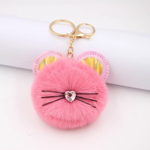 Cute pink faux fur cat keychain with heart crystal and golden lobster clasp on white background