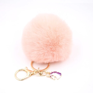 Detail of pink faux fur pompom keychain with golden lobster clasp and unicorn charm