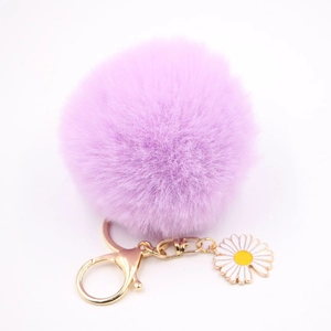 Détail d'un porte-clés pompon violet doux avec breloque marguerite et fermoir doré