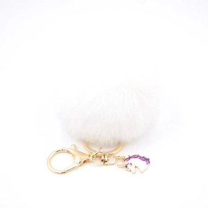 Detailed close-up of a fluffy white faux fur unicorn keychain with gold metal lobster clasp