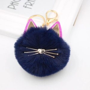 Close-up of navy blue plush cat keychain with golden whiskers and sequin ears
