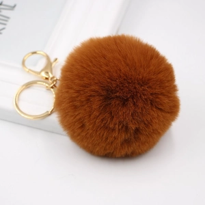 Detailed macro view of caramel faux fur keychain with polished gold lobster clasp