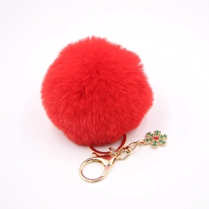 Détail d'un porte-clés en fausse fourrure rouge avec breloque flocon de neige dorée