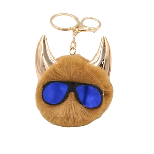 Brown fluffy faux fur monster keychain with golden horns and blue sunglasses decoration