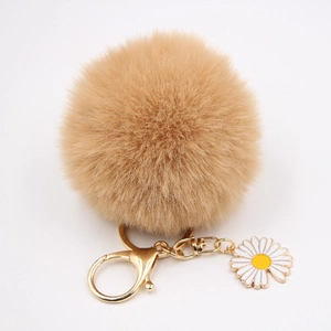 Détail du porte-clés pompon en fausse fourrure kaki avec anneau doré et breloque marguerite