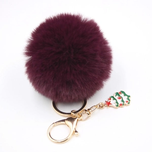 Détail du porte-clés en fausse fourrure violette avec fermoir doré et pendentif sapin