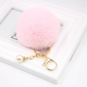Pink faux fur pompom keychain with golden clasp and elegant pearl detail for women