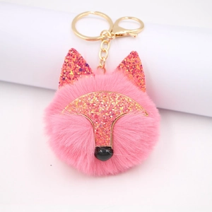Détail macro du porte-clés renard rose à paillettes avec fermoir doré et fourrure douce