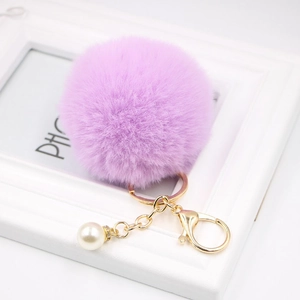 Purple faux fur pompom keychain with golden metal clasp and decorative pearl charm