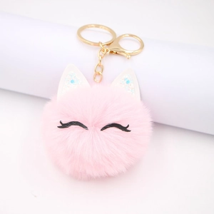 Pink plush cat bag charm with sequin ears and gold keychain hanging on white stand