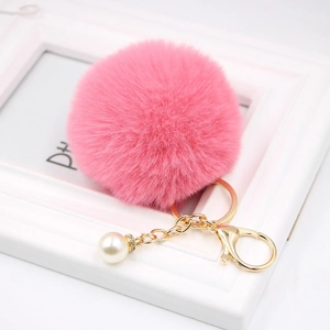 Pink faux fur pompom keychain with gold lobster clasp and white pearl detail charm