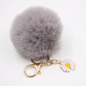 Détails d'un porte-clés marguerite gris duveteux avec quincaillerie dorée et pendentif