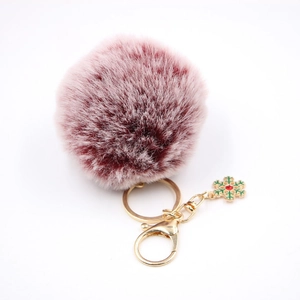 Détail du porte-clés pompon en peluche avec breloque flocon de neige et fermoir doré