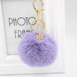 Plush purple pompom keychain with golden snowflake charm and secure metal clasp