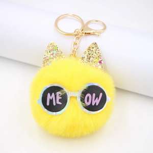 Yellow faux fur pom pom keychain with glittery cat ears and sunglasses featuring MEOW text