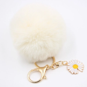 Détail d'un porte-clés pompon marguerite avec fermoir mousqueton doré et petite fleur