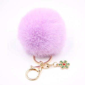 Détail d'un porte-clés violet à pompon avec flocon de neige doré et strass rouge