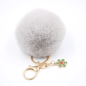 Détail du porte-clés pompon gris avec fermoir doré et pendentif flocon de neige