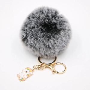 Détail du porte-clés en peluche avec pendentif licorne dorée et fermoir mousqueton