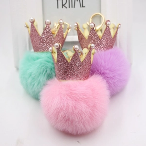 Vue détaillée des porte-clés en fausse fourrure rose, violette et menthe avec couronne à paillettes