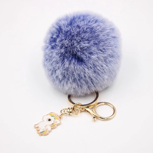 Détail du porte-clés licorne en peluche bleue avec fermoir doré et pendentif émaillé coloré