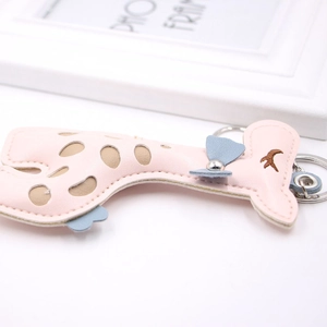 Vue détaillée du porte-clés girafe en cuir PU rose avec broderie et nœud bleu ciel