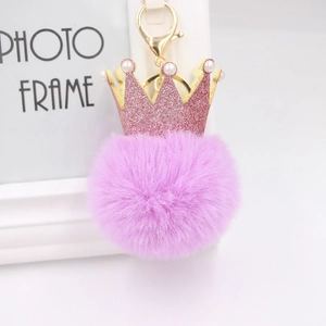 Détail d'un porte-clés en fausse fourrure violette avec couronne rose et perles blanches
