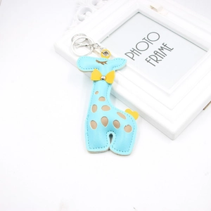 Détail du porte-clés girafe en cuir PU bleu clair avec pois colorés et fermoir argenté
