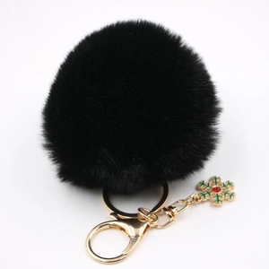 Gros plan du porte-clés pompon noir avec breloque flocon de neige dorée et fermoir