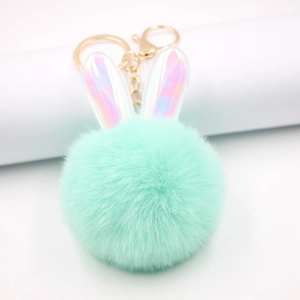 Dettaglio portachiavi a orecchie di coniglio in peluche verde menta con materiale laser dorato