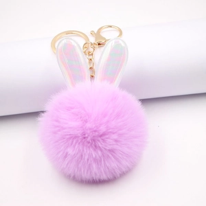 Dettaglio portachiavi a orecchie di coniglio in peluche rosa con finitura olografica e oro