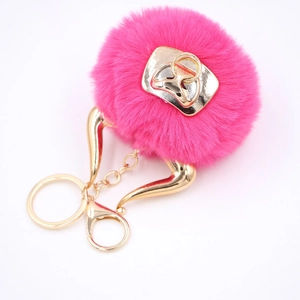 Detail of rose red faux fur pom-pom keychain with gold hardware and lobster clasp