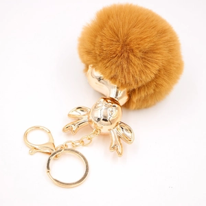 Porte-clés fausse fourrure biche avec pompon marron et bois dorés sur fond blanc