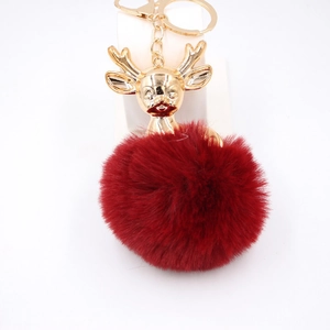 Détail du pompon en fausse fourrure rouge foncé et du porte-clés tête de renne doré