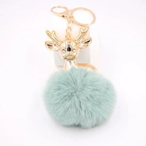 Détail du cerf en métal doré et du pompon en fausse fourrure vert menthe du porte-clés