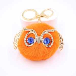 Détail du porte-clés hibou en fausse fourrure orange avec yeux bleus et fermoir doré