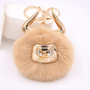 Detailed close-up of the plush bull keychain with golden metal horns and nose ring