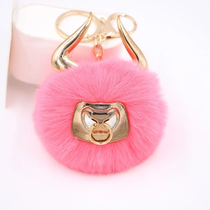 Detailed view of pink faux fur bull keychain with golden metal horns and ring