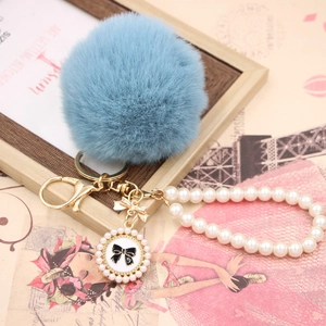 Sky blue faux rabbit fur pompom keychain with pearl wristlet and bow charm detail