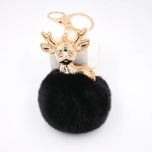 Détail du porte-clés cerf avec charm en métal doré et pompon en fourrure noire douce
