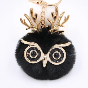 Vue détaillée du porte-clés hibou en peluche noire avec bois dorés et yeux brillants