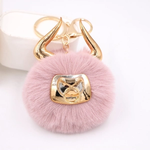 Pink plush bull head keychain with golden horns and D-ring, featuring soft faux fur texture