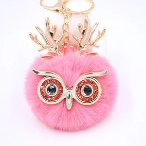 Vue détaillée du porte-clés hibou en peluche rose avec bois dorés et fermoir métallique