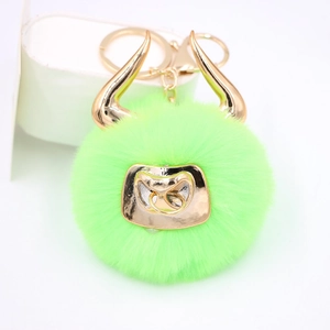 Detailed close-up of a neon green plush bull keychain with golden horns and metallic nose ring