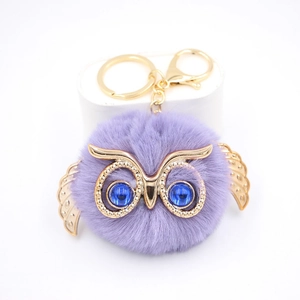 Porte-clés hibou mignon en fausse fourrure violette avec ailes dorées et yeux bleus