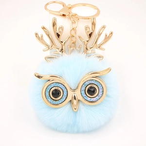 Détail du porte-clés hibou en fausse fourrure bleue avec bois dorés et strass