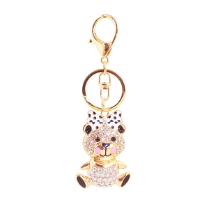 Sparkly rhinestone teddy bear keychain with polka dot bow and polished golden finish