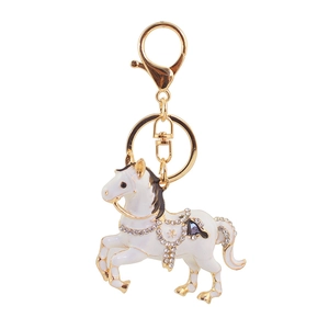 Détail des strass en cristal et de l'émail blanc sur le porte-clés cheval doré
