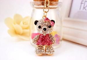 Detail shot of a crystal teddy bear keychain with pink and white rhinestones and gold clasp